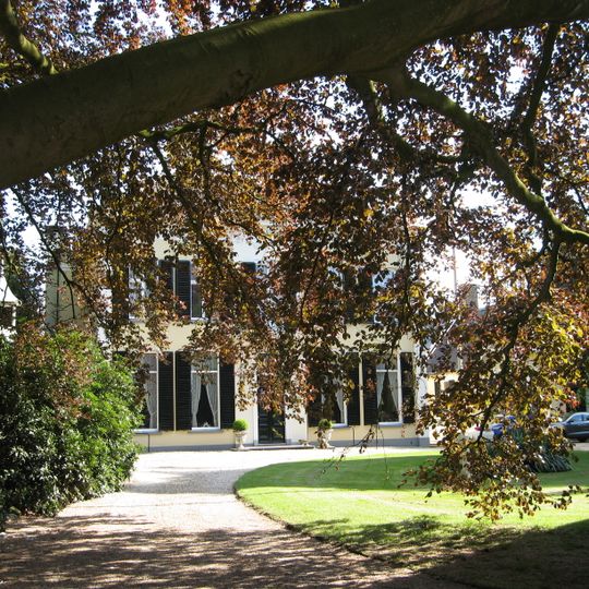 Blokvormige villa heeft twee bouwlagen en is schuin op de weg gesitueerd