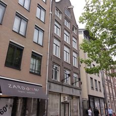 Huis met 18e-eeuwse gevel onder klokvormige top met rollagen