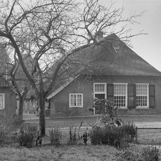 Boerderij onder een met pannen en riet gedekt afgewolfd zadeldak