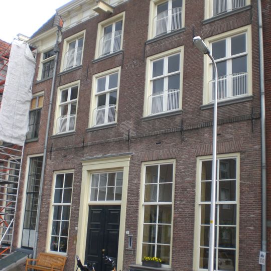 Tweetal 16e-eeuwse panden in de 18e eeuw samengevoegd onder schilddak en voorzien van gecombineerde kroonlijst met trigliefenconsoles