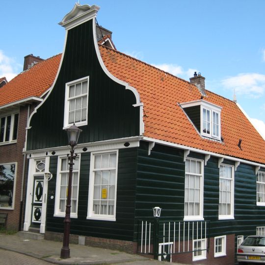Houten huis met klokgevel , onderpui met fries in empirestijl, aan achterzijde puntgevel