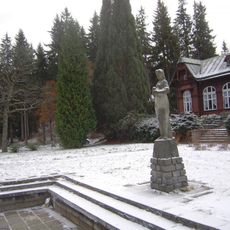 Socha dívky před budovou Letních lázní v Karlově Studánce