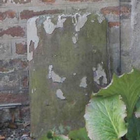 Parish boundary stone against front wall of No.60