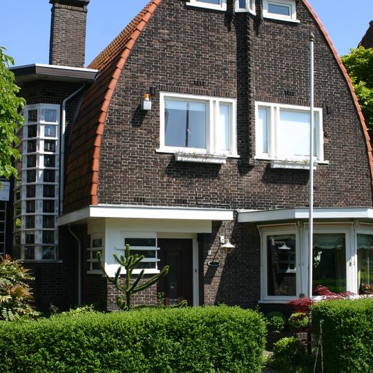 Vrijstaande villa, in Amsterdamse Schoolstijl, deel uitmakend van een samenhangend ensemble van woningen