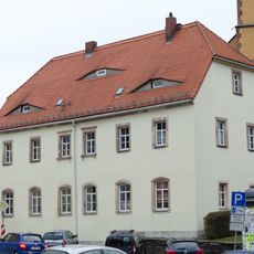 Ehemalige Schule (Rektoratsgebäude), später Wohnhaus in offener Bebauung mit Gedenktafel des Stadtbrandes von 1709 an der Traufseite des Hauses An der Kirche 6