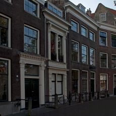 Een pandje met bakstenen lijstgevel met stucdecoratie. Stoephek