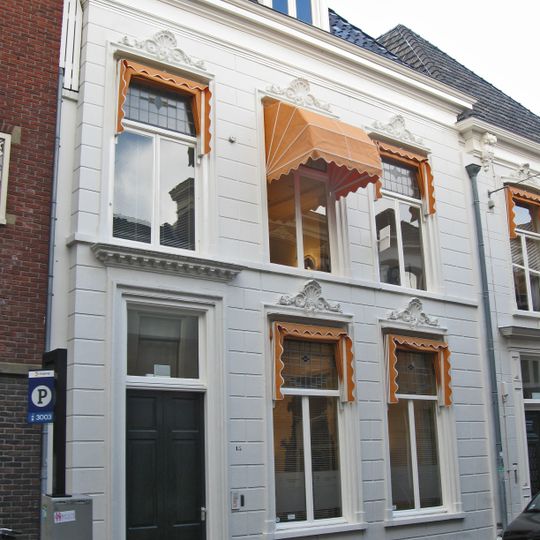 Wit gepleisterd pand met omlijste vensters