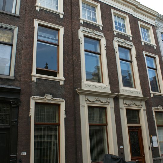 Pand met monumentale lijstgevel ter breedte van vier vensterassen, parterre en twee verdiepingen