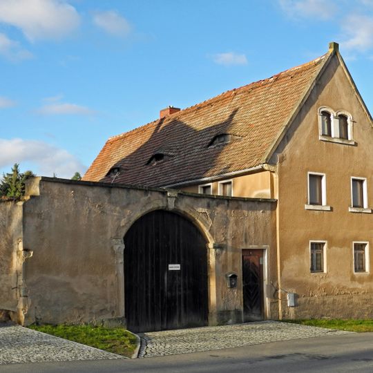 Wohnstallhaus eines Bauernhofes, dazu Hofmauer mit Torbogen und Pforte Dorfplatz 8