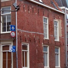 Pand met in de zijgevel aan de Minnemastraat talrijke muurankers en ontlastingsbogen