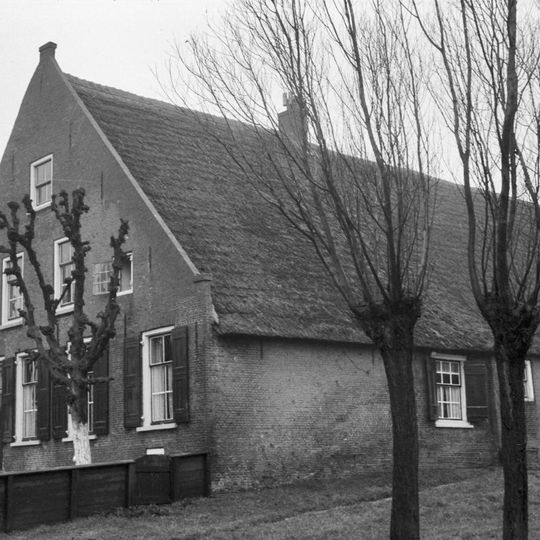 Grote boerderij met rieten zadeldak en woongedeelte met hoge, Ysselstenen puntgevel met vlechtingen. Vensters met luiken en zesruitsschuiframen