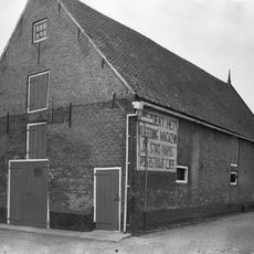 Bedrijfsruimte van stadsboerderij, schuur met tuitgevel aan de straat