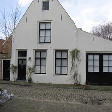 Huis met gepleisterde topgevel aan de straat