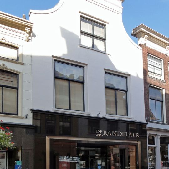 Pand met tuitgevel, afgedekt door lijst, gepleisterd. Pui en ramen modern