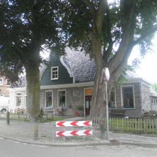 Stelphoeve met ingezwenkte houten topgevel boven de kroonlijst