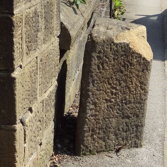 Gritstone pillar with three cup marks in the north pavement of the A65 at Horsforth, 440m south east of the roundabout at Low Fold