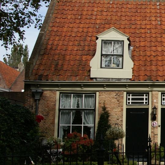 Eenvoudige woning onder zadeldak met toppilaster ter halverwege