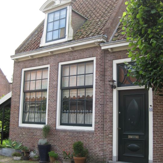 L-vormig huis, in hoofdzaak. Twee ingangen met vroeg 19e-eeuwse deur en snijraam. Drie dakkapellen met gebogen doorbroken frontons. Inwendig vier gesneden laatgotische sleutelstukken