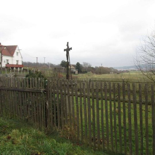 Kříž za plotem v Neuměři