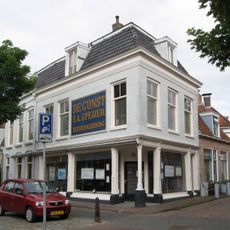 Pand onder zadeldak tegen halsgevel met aanzetkrullen en gezwenkte lijst