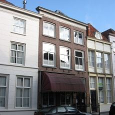 Huis onder schilddak en met lijstgevel in schoon metselwerk, waarin segmentvormig overtoogde vensters