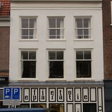 Pand met gepleisterde lijstgevel, beneden verbouwd