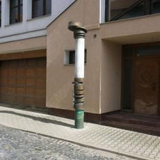 Plastika z kamene a kovu u domu 261 v ulici U Kapličky v Brandýse nad Labem