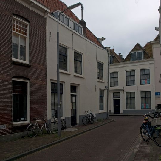Apart genummerde ingang in gepleisterde zijgevel van het pand Wagenaarstraat 11