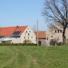 Seitengebäude und zwei Scheunen eines Vierseithofes sowie zum Gehöft führende Einfriedungsmauer Steindörfel 9