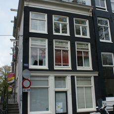 Hoekhuis met voorgevel onder rechte lijst met consoles en zijstoep met leuning