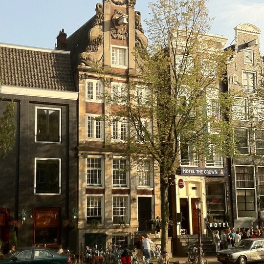 Pand met indrukwekkende pilaster-halsgevel met enorme dolfijnen als vleugelstukken